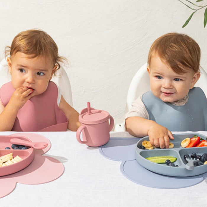 Ekologiska barnserviser i bambu, silikon och rostfritt stål upplagda på ett matbord