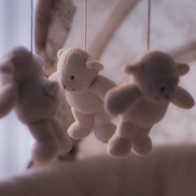 Mjuka nallebjörnar som hänger över en babysäng